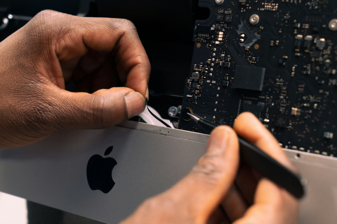 Technicien réparant un MacBook en atelier